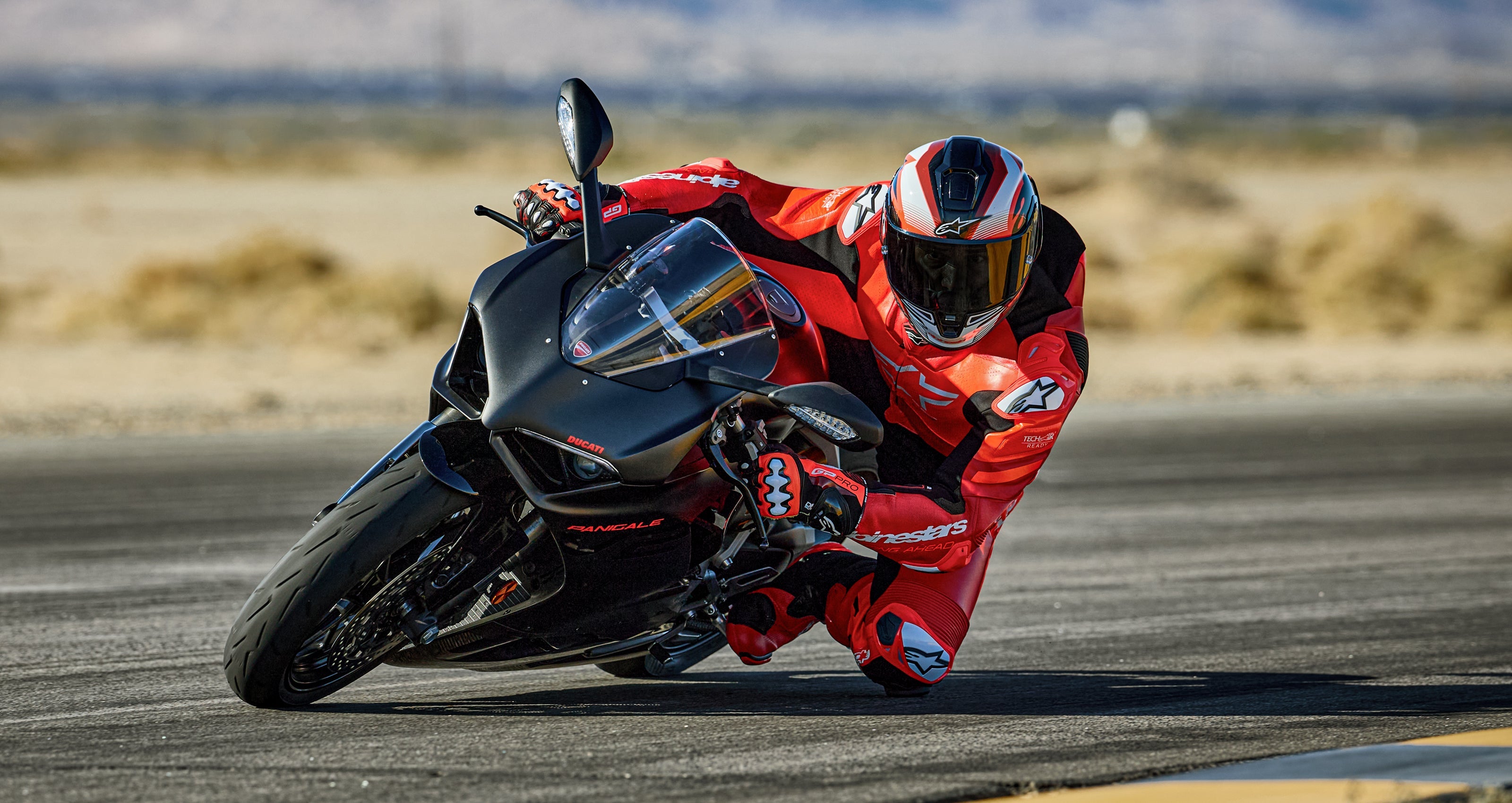 Alpinestars GP Plus V4 Sprint 1PC Leather Suit, Red Fluo and White racing suit, Tech-Air ready, rider leaning on track.